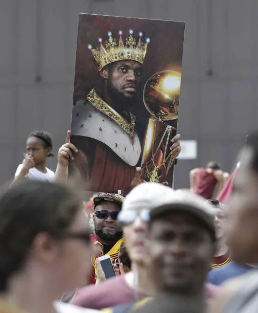 A man holds up a photo of Cleveland