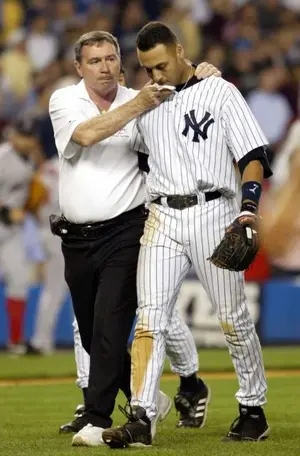 New York Yankees trainer Gene Monahan, left, tends