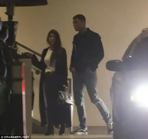 Man of style: Her male pal kept things casual in his black and white sneakers and jacket