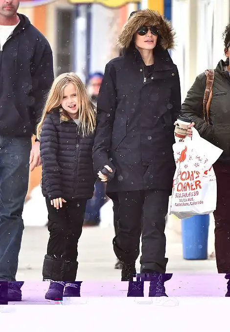 Effortless: Despite pulling the hood over her head, the brunette's naturally striking features and stunning complexion was still clear to see as she took her youngest daughter out