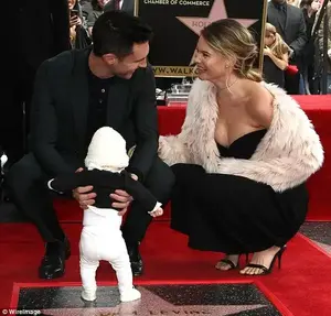 The couple beamed at each other as Levine held their daughter in his hands