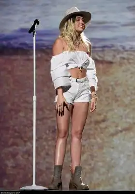Back to her roots: She kept her look simple with off-the-shoulder crop top and white daisy dukes