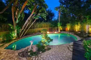Take a dip: Walls of glass open to a private back yard and lagoon-style pool that is surrounded by a flagstone paved terrace