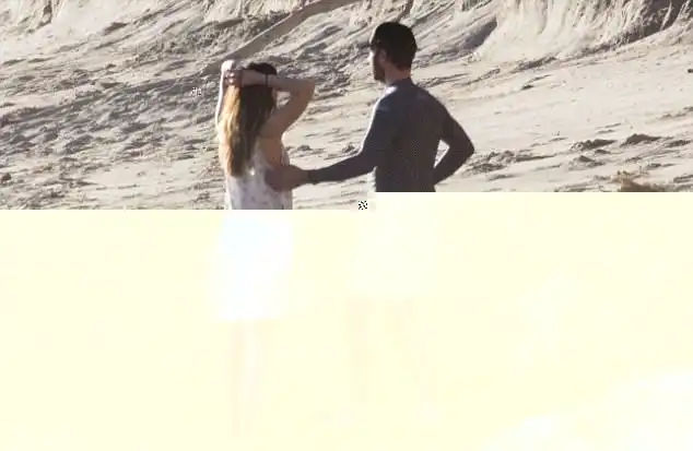 Staying close: Chris wore a navy west suit top with swim trunks, adding a baseball cap