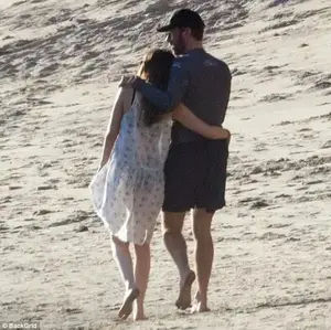 Blissful: The duo, who were first linked romantically in October, had their arms wrapped around each other while strolling along the water