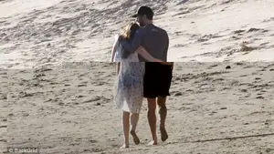 In their own world: Dakota sported a slightly sheer floral cover up with her black swimsuit underneath