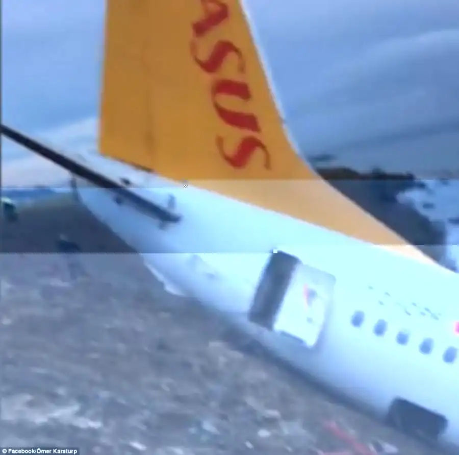  One of the exit doors can be seen wide open after passengers used it to evacuate the plane following the scary crash