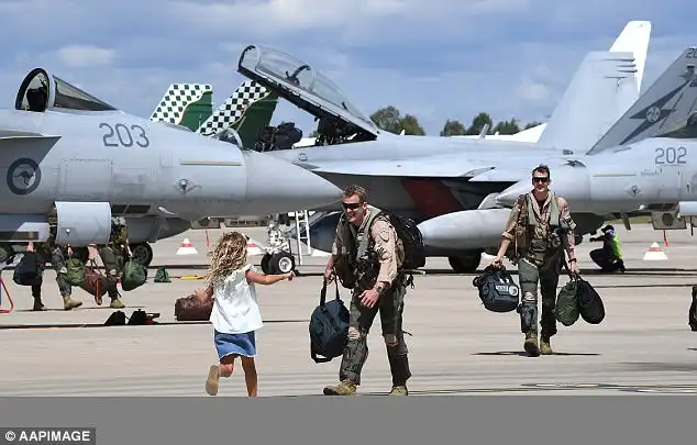  A young girl couldn't wait to hug her father, sprinting across the tarmac before leaping into his arms