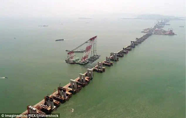 Mission impossible: Chinese workers are building a high-speed railway bridge (pictured) off the coast of south-east China, which is a 'no-go zone' for bridge builders due to high winds