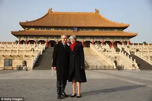 Theresa May and husband Philip posed for a picture inside the Forbidden City in Beijing today. The PM seemed slightly taken aback to be told the Chinese were calling her 'Auntie May'