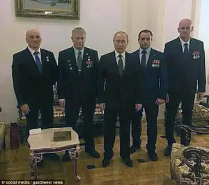 Making friends: Utkin, far right, is photographed with other Wagner army chiefs and Putin at a Kremlin ceremony