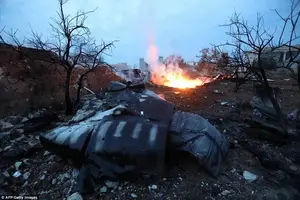 Smoke billowing from the site of a downed Sukhoi-25 fighter jet in the the Syrian city of Saraqib