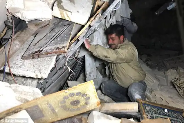 Chlorine gas left civilians gasping for air in a rebel-held Syrian town after a chemical attack as Bashar al-Assad's regime launched a wave of airstrikes, activists have claimed. Pictured: rescuers at work after a strike on Kafr Nabl  in Idlib