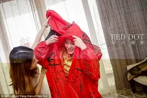 Chen Minyi wears a traditional Chinese wedding dress underneath her T-Rex costume