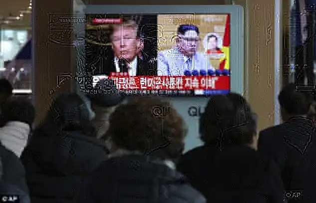 People look a TV screen showing Mr Trump and Kim at Seoul train station in South Korea today