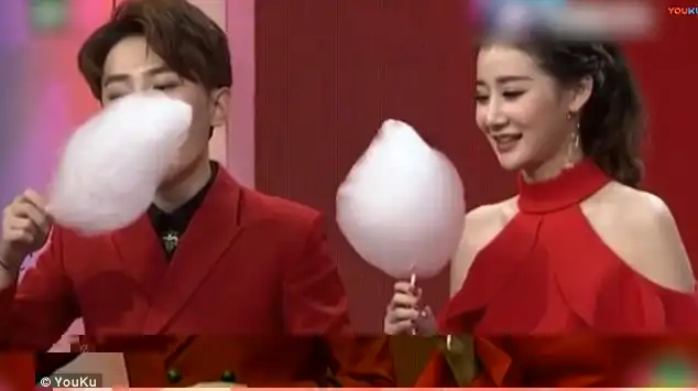 TV host An Qi, (right) is competing with her guest, Zhao Re, (left) for a candy floss challenge