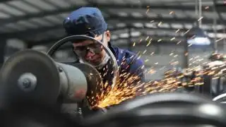 A worker welds wheel hubs of baby carriages that will be exported at a factory in Hangzhou in China