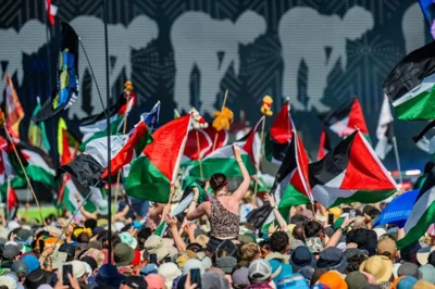 Mandatory Credit: Photo by Guy Bell/Shutterstock (15378260t) The crowd is so huge that the area is shut off to avoid a crush. The people were very supportive and many had Palestine or Irish flags, Palestine Action t-shirts of balaclavas - Kneecap play the west holts stage in front of a see of Irish and Palestine flags - Saturday at The 2025 Glastonbury Festival, Worthy Farm. Glastonbury, Kneecap, The 2025 Glastonbury Festival., Worthy Farm, Pilton, Somerset, UK - 28 Jun 2025