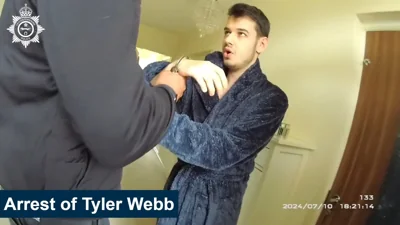 Photograph of Webb's arrest, showing him in a blue dressing gown.