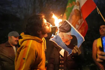 Protesters in London burning a photo of Iran's Supreme Leader Ayatollah Ali Khamenei outside the Iranian embassy.