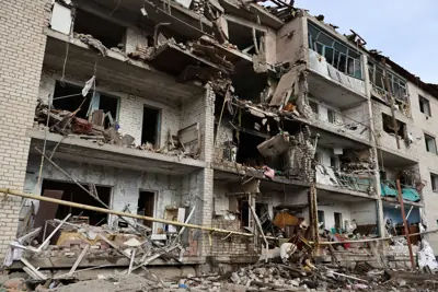 An apartment building in ruins after an air strike on Komyshuvakha, Zaporizhzhia region, Ukraine, highlighting the urban combat scenarios where humanoid robots could be effective.