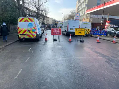 Cleanup operations ongoing on Caledonian Road, with engineers pumping out floodwaters after the burst pipe.