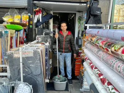 Ali Ahmed, owner of Alibaba convenience store, cleaning up after the devastating flood in Caledonian Road, London.