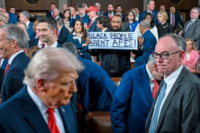 Representative Al Green holding up a protest sign during Donald Trump's State of the Union address.