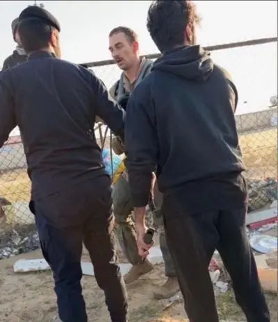 A US pilot is approached by armed men in the desert after crashing.